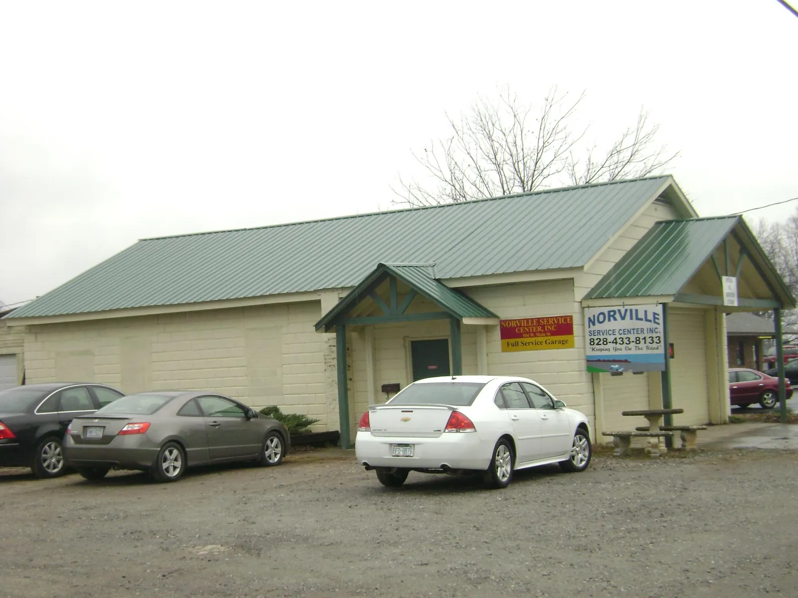 Green metal roof on a service garage with a covered entry in Geneva